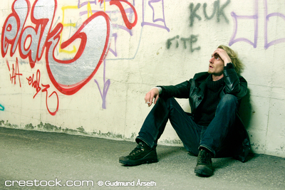 Young man sitting in an underpass
